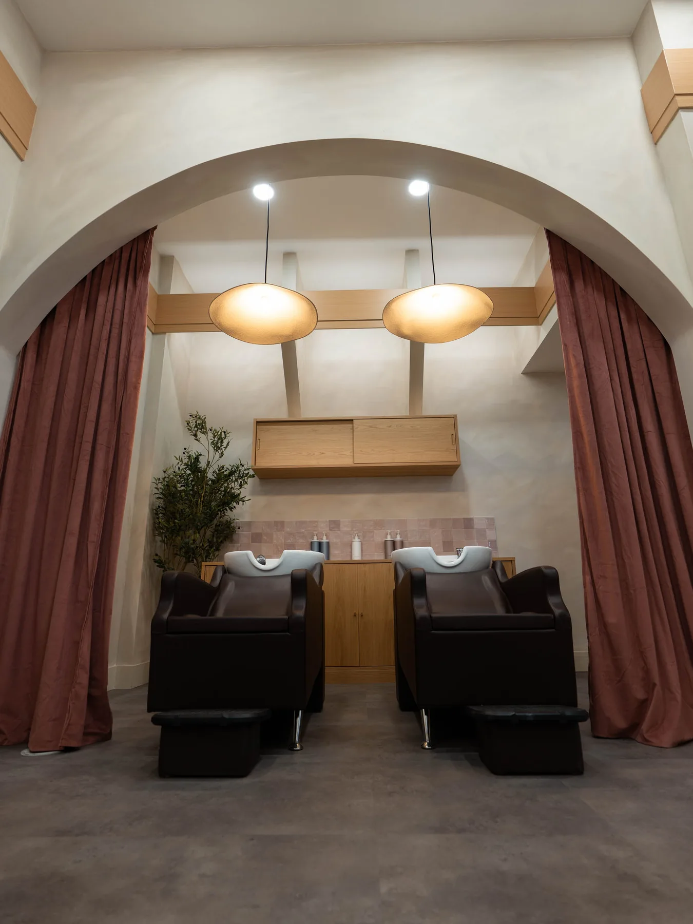 Shampoo area framed by an arch and rose curtains at the Blonde Culture hair salon in Winnipeg