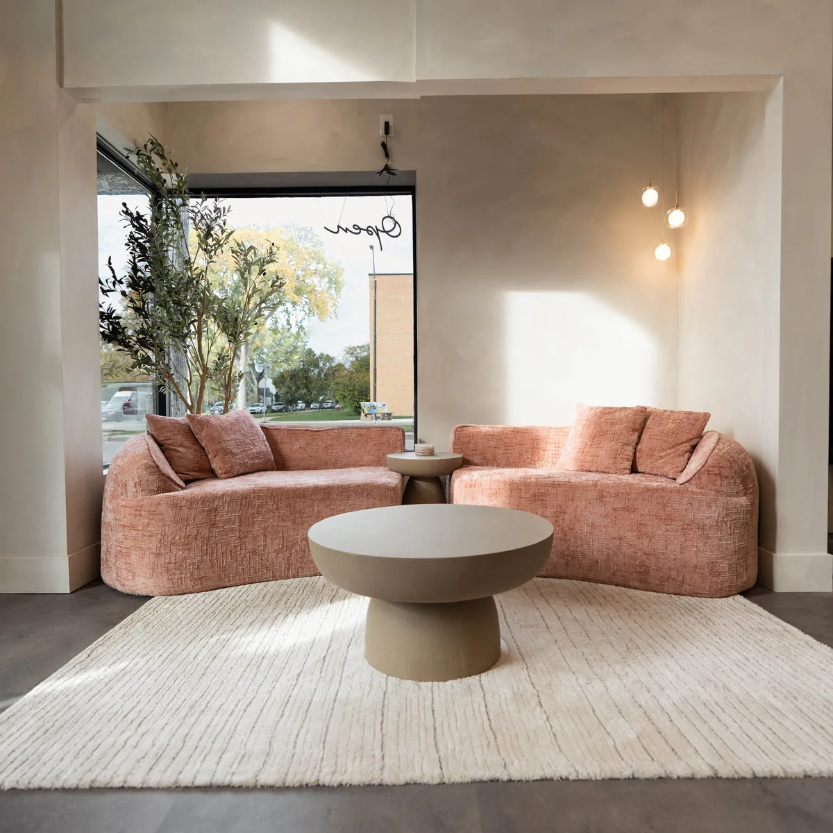 Lounge with a curved rose sofa at Blonde Culture Winnipeg